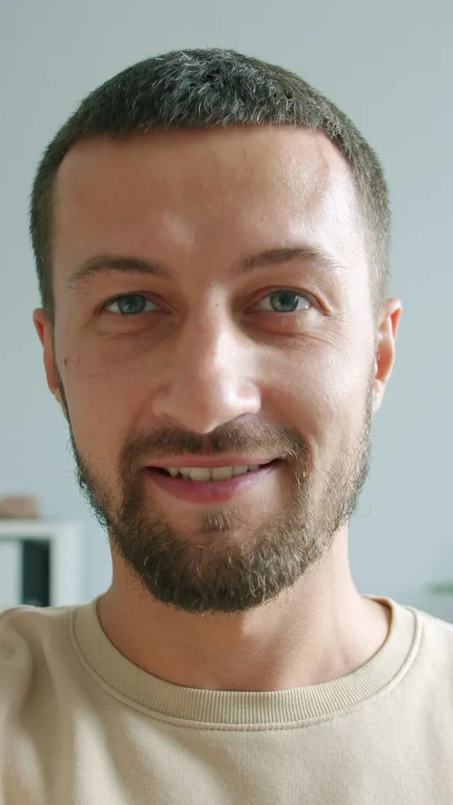 Smiling bearded man photographed at home